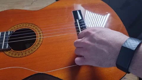 Restringing a classical guitar using new nylon strings Stock Footage 194540392