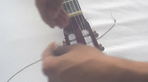 Restringing Your Classical Guitar (turning) side view Stock Footage 68001451