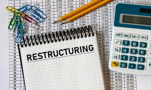 RESTRUCTURING - word in a notebook on the background of a table with numbers, Stock Photos