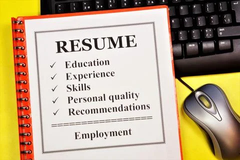 Resume. The document is in a folder on the keyboard. Stock Photos