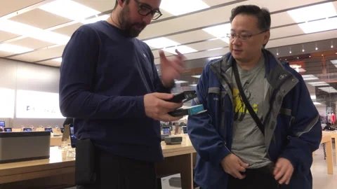 Retail Assistant Helping Customer with Product in Modern Electronics Store Stock Footage 342341028