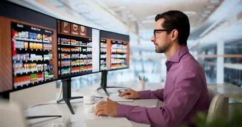 Retail Manager Uses Computer To Improve Supermarket Shelf Layout Efficiency. Stockfoto's