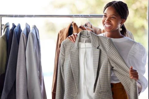 Retail, shopping and black woman in store with clothes choice on rack for sale Stock Photos