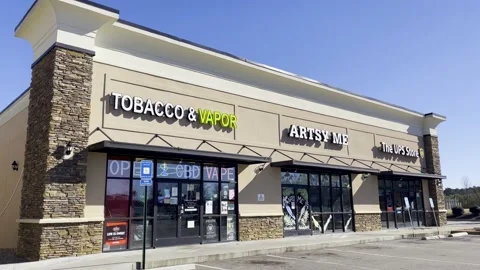 Retail strip mall the ups Store Tobacco and vape and Artsy Me storefronts e.. Stock Footage 228688885