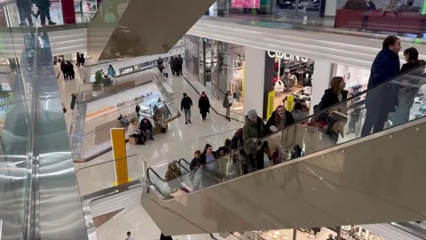 Retail therapy: crowds navigate a lively shopping center, exploring stores and e Vidéo 264564460