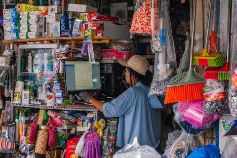 Retail Vendor Using PC at Crowded Merchandise Stall Stock-Fotos