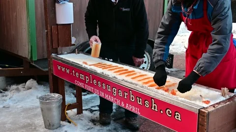 Retailer Making Maple Syrup Sugar with Sticks on Ice and Selling on Street Stock Footage 232959960