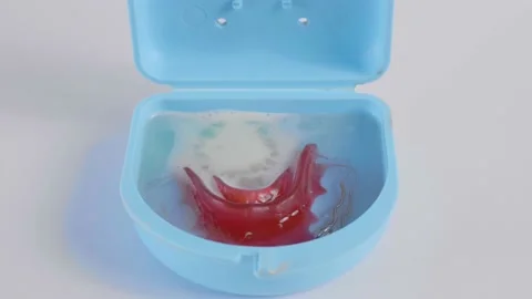 Retainer is placed in a water container and effervescent tablets are added to Stock Footage 188427199