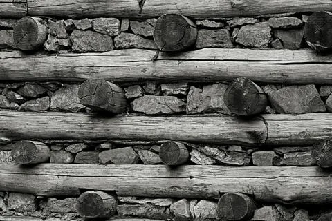 A retaining wall made of logs and natural stone. Стоковые фото