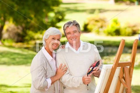 Retired couple painting in the park Stock Photos