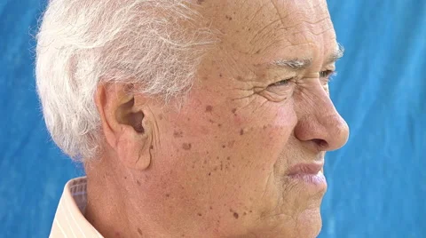 Retired elder front portrait: old man looking in camera on blue background Stock Footage 64304358