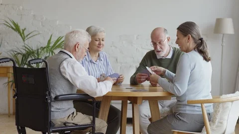 Retired elderly people playing cards in nursing home Stock Footage