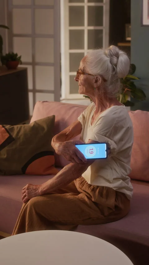 Retired Lady Checking Blood Sugar with Smartphone and Sensor Patch at Home Stock Footage 320972254