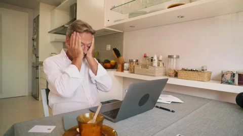 Retired man feeling stressed and overwhelmed using laptop at home Stock Footage 343218603