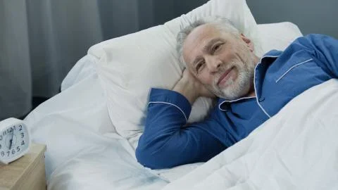 Retired man waking up active and full of energy after comfortable healthy sleep Stock Photos