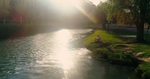 Retired by the river reading a book Stock Footage 124381742