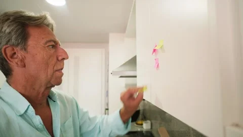 Retired senior man with memory loss pointing at sticky notes Stock Footage 343218927