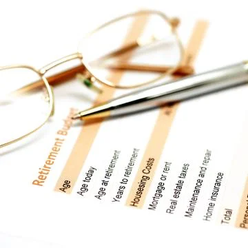 Retirement plan document with pen and glasses Stock Photos