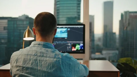 Retoucher working from home on computer, view of Downtown LA 動画素材 127402199