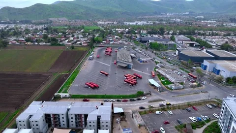 Retreating reveal pulling back from white apartment blocks and a bus depot with Vidéo 348246789