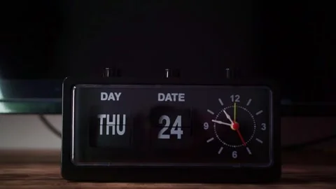 Retro alarm clock with flip display displayed on the wooden table, dark Stock Footage 344432268