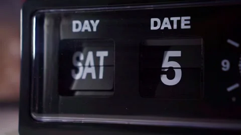 Retro alarm clock flipping day and date numbers close up, dim lighting, time Stock Footage 345869608
