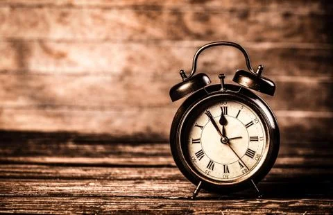 Retro alarm clock on a table. Stock Photos