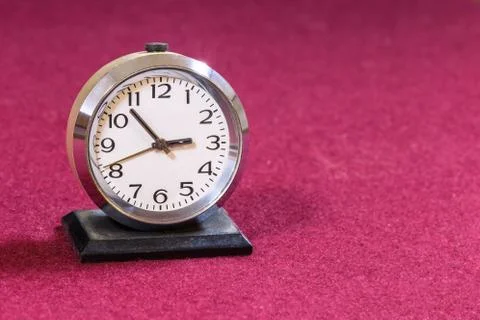 Retro alarm clock on table on red Foto stock