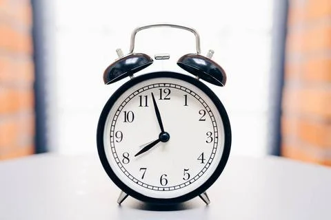  Retro alarm clock on table Retro alarm clock on table on white background... Foto stock