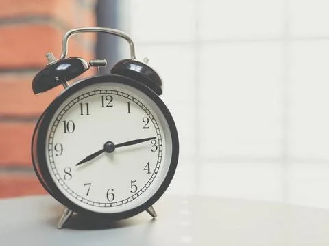  Retro alarm clock on table Retro alarm clock on table with vintage backgr... Foto stock