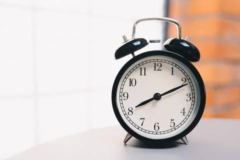  Retro alarm clock on table Retro alarm clock on table with vintage backgr... Foto stock