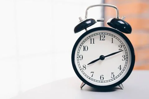 Retro alarm clock on table Retro alarm clock on table with vintage backgr... Foto stock