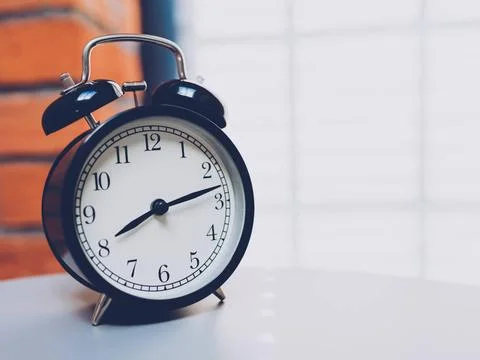  Retro alarm clock on table Retro alarm clock on table with vintage backgr... Foto stock