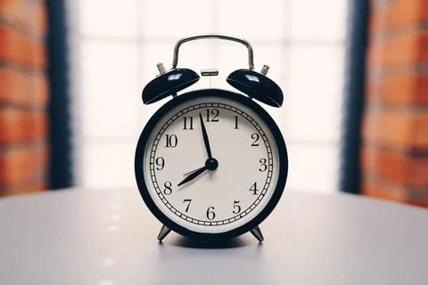  Retro alarm clock on table on white background Retro alarm clock on table... Stock Photos