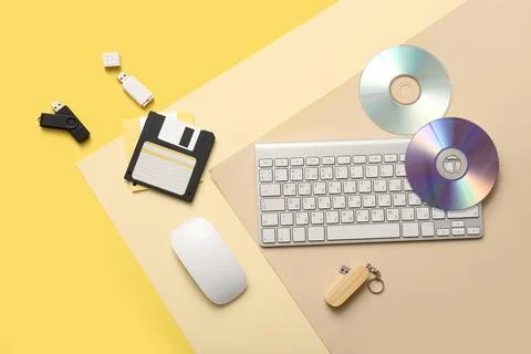 Retro and modern data storage devices with computer peripherals on yellow bac Stock-Fotos