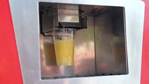 Retro automatic machine fills a plastic glass with juice. Stock Footage 173502228