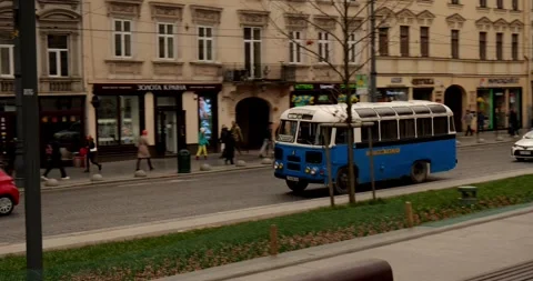 A retro bus drives through the old beautiful city Stock Footage 240102975