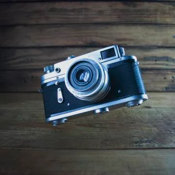 Retro camera in the air on the background of old wooden background, vintage Foto stock