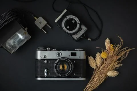 Retro camera on the black background. Old gear for photography. Stylish backg Stock Photos