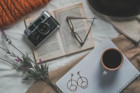 Retro camera, notepad, cup of coffee, hat, glasses, book and flowers on a whi Stock Photos