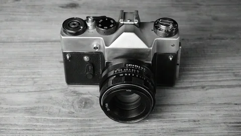 Retro camera on a wooden table, black and white Stock Footage 112922532