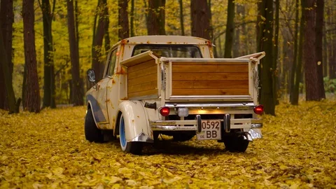 Retro cars in a fall forest with falling leaves custom truck creative idea with Stock Footage 85239155