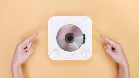 Retro CD Player on Yellow Background with Pointing Hands, Modern Audio Stock Photos