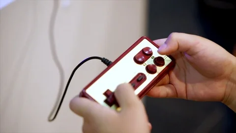 Retro classic gamepad and hands of player. Player pressing buttons and playing Stock Footage 79101733