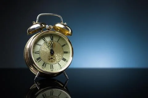 Retro clock, five to twelve, blue background Stock Photos