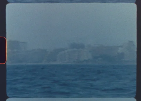 Retro coastal cityscape seen across the ocean on vintage 8mm film Stock Footage 319829171