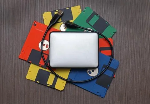 Retro colorful floppy disks stack with modern external  hard drive on top Stock Photos