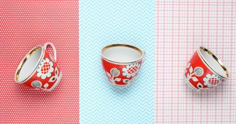 Retro cups with red patterns on tablecloth. Top view. Stock Photos
