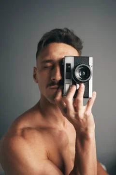 Retro de un chico moreno with bigote with analogical camara Stock Photos