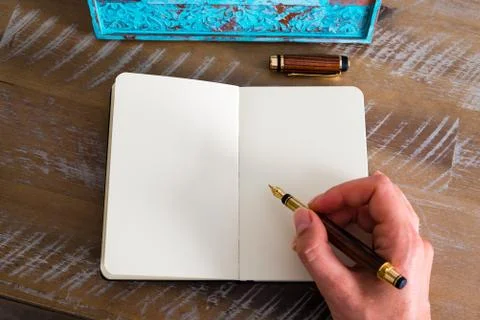 Retro effect and toned image of a woman hand writing a note with a fountain p Stock Photos